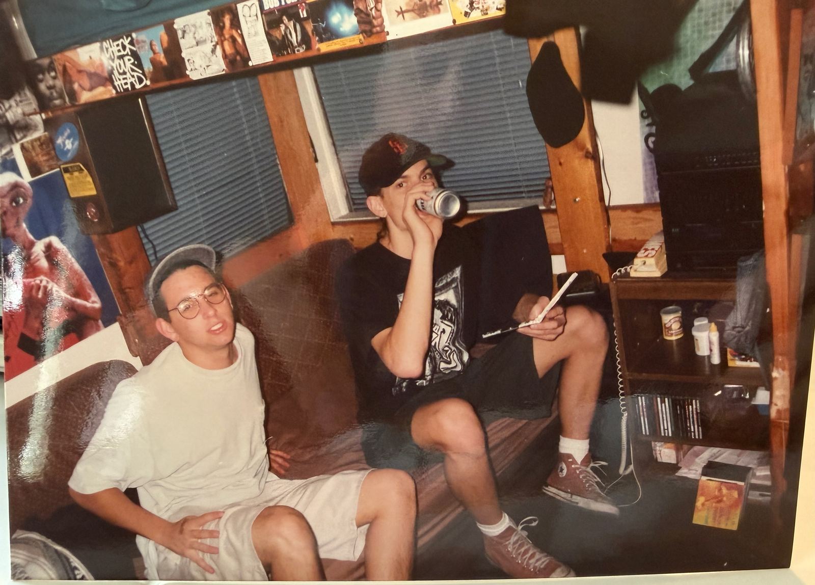 Young Alan and a friend in a poster-covered dorm room